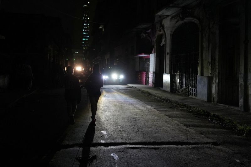 © Reuters. FILE PHOTO: People walk on the street during an electrical grid collapse, in Havana, Cuba, December 4, 2024. REUTERS/Alexandre Meneghini/File Photo