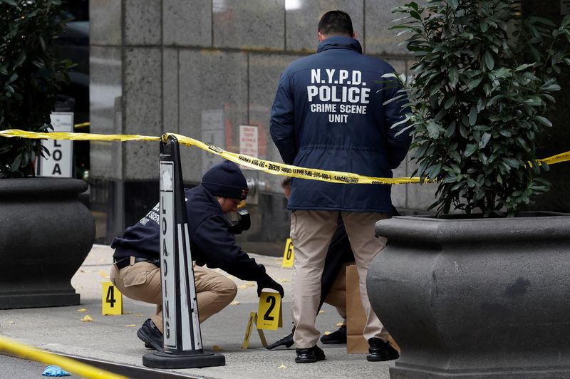 &copy; Reuters. FILE PHOTO: Members of the NYPD Crime Scene Unit work near evidence markers placed where shell casings were found at the scene where the CEO of UnitedHealthcare Brian Thompson was reportedly shot and killed in Midtown Manhattan, in New York City, US, Dece