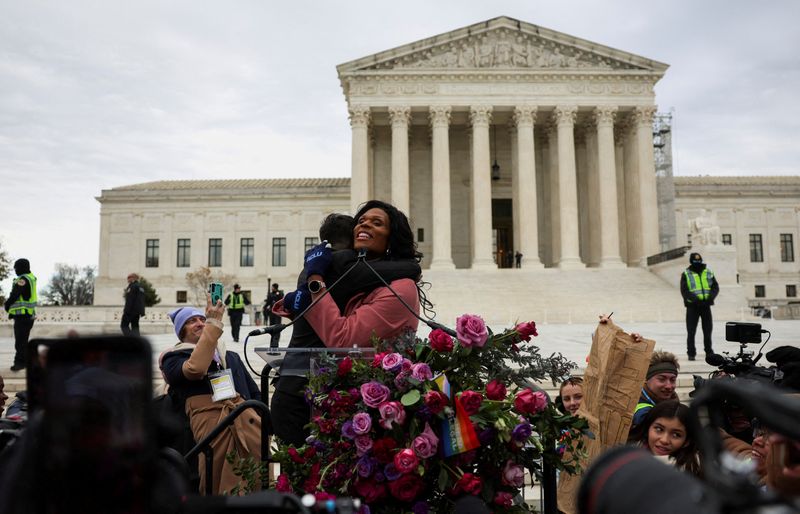 © Reuters. FILE PHOTO: Chase Strangio, the first openly transgender person to argue in front of the U.S. Supreme Court, accompanied by the legal team, is embraced by MC Peppermint outside the court following arguments over an appeal by U.S. President Joe Biden's administration of a lower court's decision upholding a Republican-backed ban in Tennessee on gender-affirming medical care for transgender minors, in Washington, U.S., December 4, 2024. REUTERS/Leah Millis/File Photo