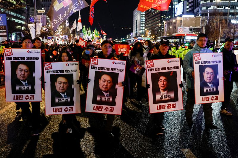 ។ Reuters. Demonstrators hold banners during a candlelight vigil to condemn South Korean President Yoon Suk Yeol's shocking announcement of a failed martial law and call for his resignation in Seoul, South Korea. December 2024. REUTERS / Kim Kyung-Hoon