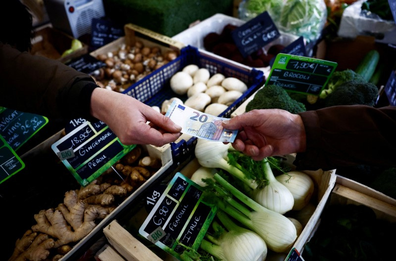 © Reuters. FILE PHOTO: A shopper pays with a twenty Euro banknote at a local market in Nantes, France, February 1, 2024. REUTERS/Stephane Mahe/File Photo