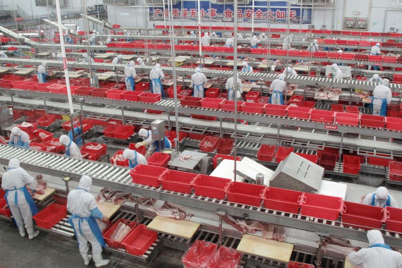 © Reuters. FILE PHOTO: Workers sort pieces of fresh pork at a processing plant of pork producer WH Group in Zhengzhou, China's Henan province, November 24, 2017. Picture taken on November 24, 2017 through a glass window. REUTERS/Dominique Patton/File photo