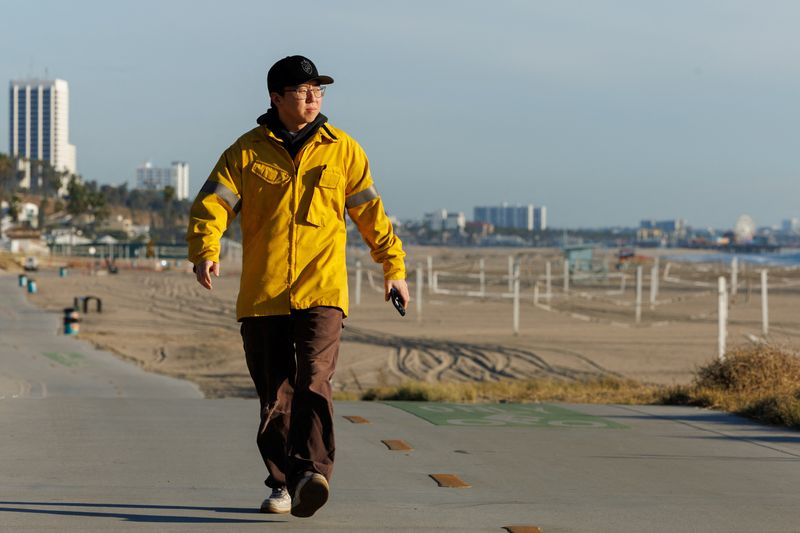 &copy; Reuters. Alex Choi, who loves documenting situations for social media and says millions of people have viewed his video of the Palisades Fire on Snap Chat and Instagram, walks along an empty beach near the Palisades Fire, in  Los Angeles  California, U.S. January 