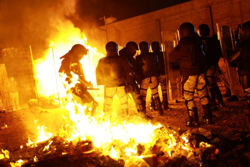 © Reuters. Members of the Mexican National Guard in riot gear take part in an operation to remove migrants from a camp, as migrants burn their belongings, in Chihuahua, Chihuahua state, Mexico January 18, 2025. REUTERS/Jose Luis Gonzalez