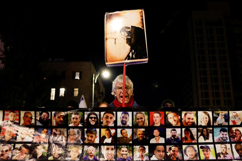 &copy; Reuters. A man holds a placard as families and supporters of the Israeli hostages kidnapped during the deadly October 7 2023 attack by Hamas attend a demonstration in support of ceasefire deal between Israel and Hamas, the day before it goes into effect, in Jerusa