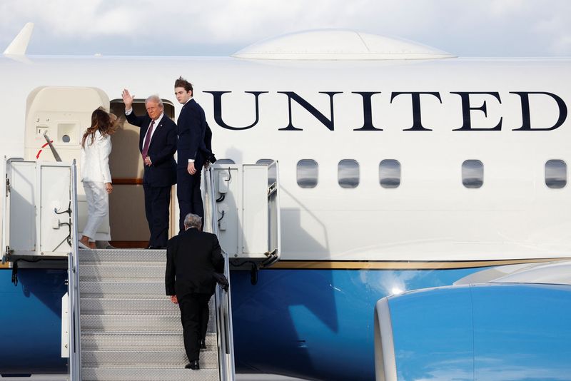 © Reuters. U.S. President-elect Donald Trump, his wife Melania and son Baron board a U.S. Air Force plane to travel to Dulles International Airport from Palm Beach International Airport in West Palm Beach, U.S. January 18, 2025. REUTERS/Marco Bello