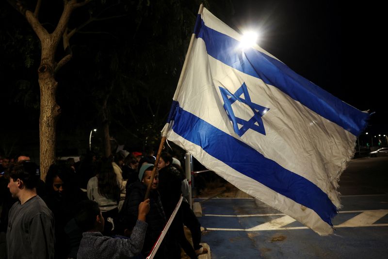 © Reuters. People gather, ahead of the expected arrival of Romi Gonen, Doron Steinbrecher and Emily Damari, three former female hostages who have been held in Gaza since the deadly October 7 2023 attack, following their release as part of a ceasefire deal in Gaza between Hamas and Israel, at Sheba Medical Center in Ramat Gan, Israel January 19, 2025. REUTERS/Ronen Zvulun