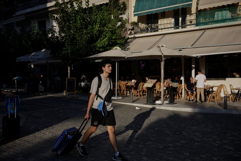 © Reuters. FILE PHOTO: A tourist carries his luggage in Athens, Greece, September 11, 2024. REUTERS/Louiza Vradi/File Photo