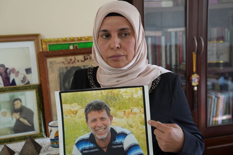 &copy; Reuters. Eman Nafe, the wife of Palestinian prisoner Nael Barghouti, who has spent 44 years in an Israeli jail, holds a picture of her husband, in her house near Ramallah, in the Israeli-occupied West Bank, January 18, 2025. REUTERS/Ismael Khader