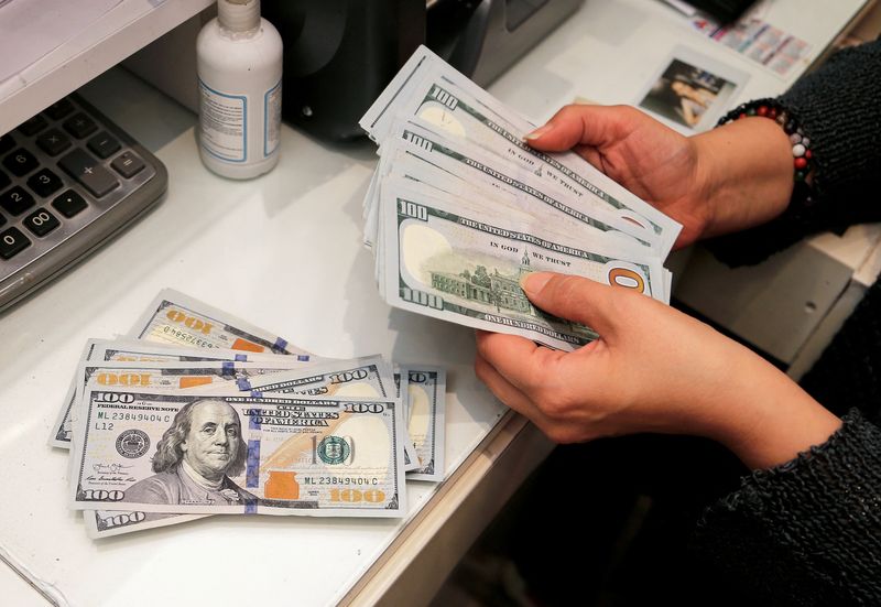 © Reuters. FILE PHOTO: A money changer counts U.S. dollar banknotes at a currency exchange office in Ankara, Turkey October 12, 2021. REUTERS/Cagla Gurdogan/File Photo