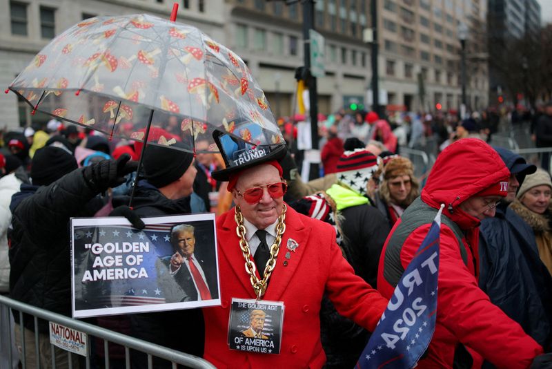 © Reuters. Gregg Donovan wears a pendant with a picture of U.S. President-elect Donald Trump as his supporters gather outside Capital One Arena, for a rally a day before he is scheduled to be inaugurated for a second term, in Washington, U.S., January 19, 2025. REUTERS/Daniel Cole 