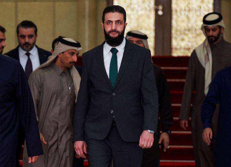 © Reuters. FILE PHOTO: Syria's de facto leader Ahmed al-Sharaa, also known as Abu Mohammed al-Golani, walks with Qatar's Minister of State Mohammed bin Abdulaziz al-Khulaifi after the ouster of Bashar al-Assad Damascus in Syria, Syria, December 23, 2024. REUTERS/Ammar Awad/File Photo