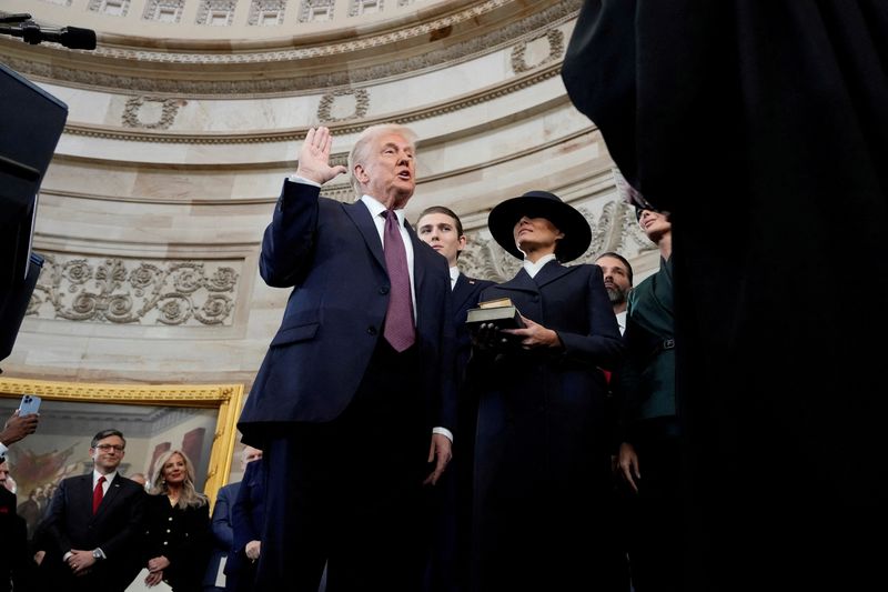 &copy; Reuters. Donald Trump é empossado como 47º presidente dos Estados Unidos pelo presidente do Supremo Tribunal, John Roberts, enquanto Melania Trump segura a Bíblia no Capitólio, em Washingtonn20/01/2025nMorry Gash/Pool via REUTERS