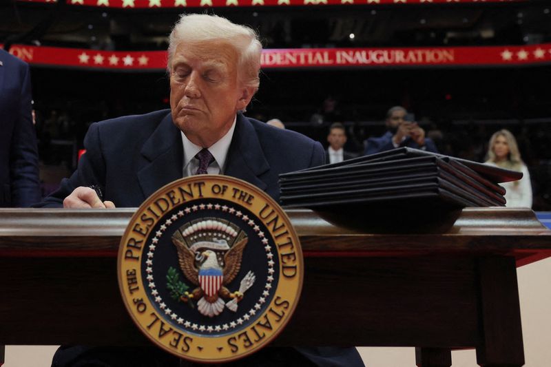 &copy; Reuters. U.S. President Donald Trump signs the third executive order during the inaugural parade inside Capital One Arena on the inauguration day of his second presidential term, in Washington, U.S. January 20, 2025. REUTERS/Carlos Barria