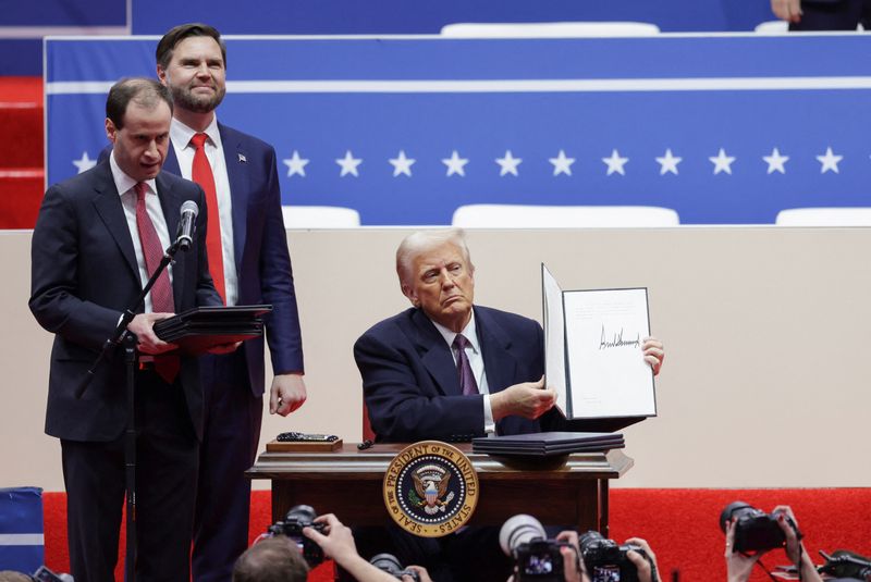 © Reuters. The President of the United States, Donald Trump, shows a signed executive order as the Vice President of the United States, JD Vance, looks on during a meeting on the day of the inauguration of his second term as President, inside Capital One , Washington, US January 20, 2025. REUTERS/Mike Segar