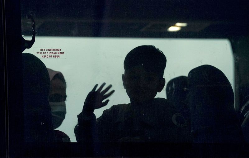 © Reuters. FILE PHOTO: A day after US forces completed their troop withdrawal from Afghanistan, an Afghan boy waves from a bus carrying refugees to a processing center as they arrive at Dulles International Airport in Dulles, Virginia, US, September 1, 2021. REUTERS/Kevin Lamarque/File Photo