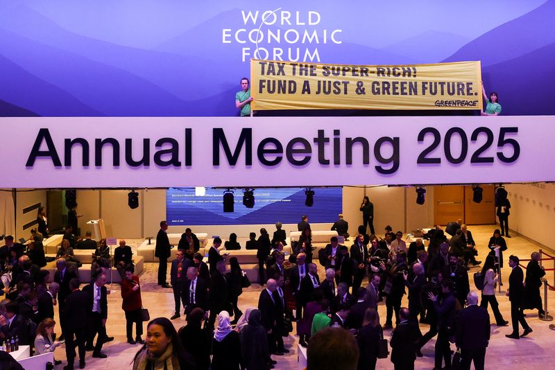 © Reuters. Greenpeace activists hold a banner as they protest in the Congress Centre during the 55th annual World Economic Forum (WEF) meeting in Davos, Switzerland, January 21, 2025. REUTERS/Yves Herman