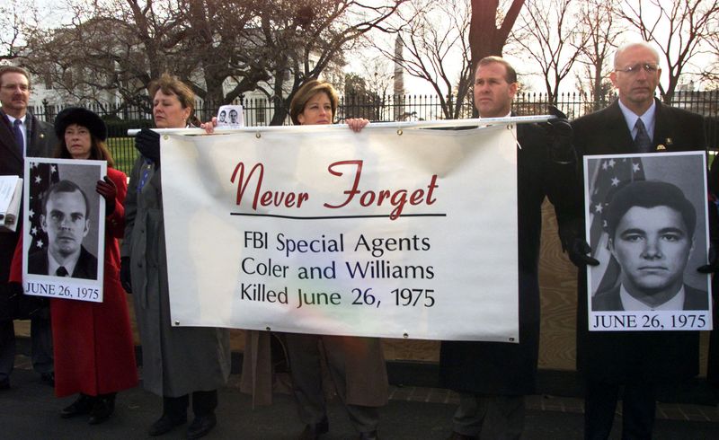 &copy; Reuters. FILE PHOTO: FBI Agents hold a banner in front of the White House during an FBI rally, December 15, 2000. The photos being held are of the murdered agents, Jack Coler (L) and Ronald Williams (R). MMR/HB/File Photo