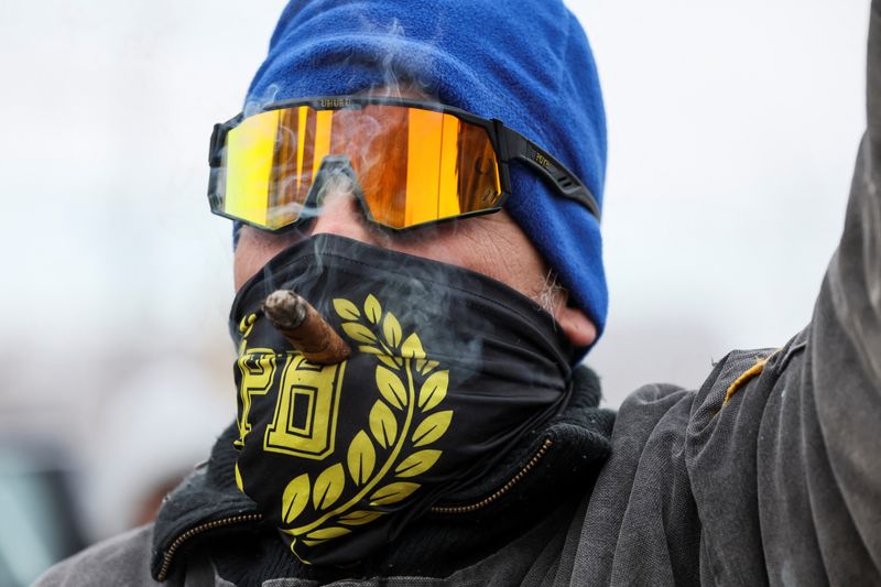 &copy; Reuters. A member of far-right Proud Boys smokes cigar, as people wait for the release of those serving time related to their involvement in January 6, 2021 attack on the U.S. Capitol, after U.S. President Donald Trump made a sweeping pardon of nearly everyone cha