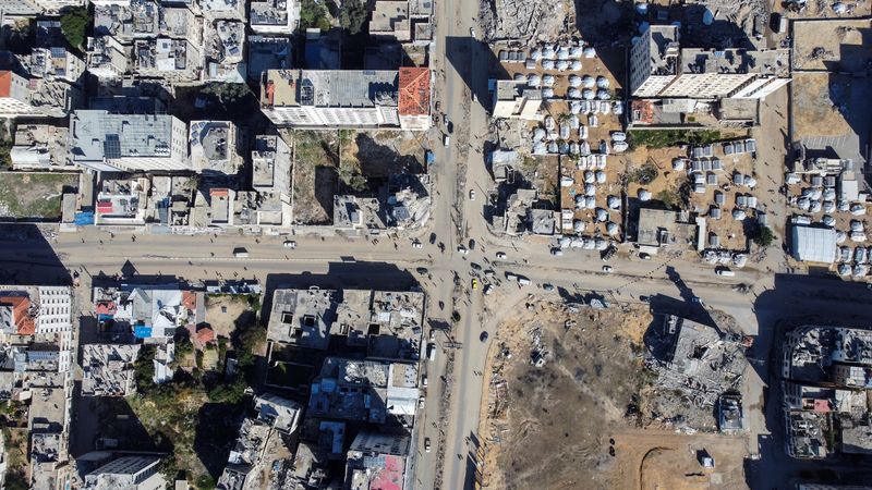 © Reuters. A drone view shows damaged and destroyed buildings as displaced Palestinians shelter in tents, following a ceasefire between Israel and Hamas, in Gaza City, January 20, 2025. REUTERS/Mahmoud Al-Basos     