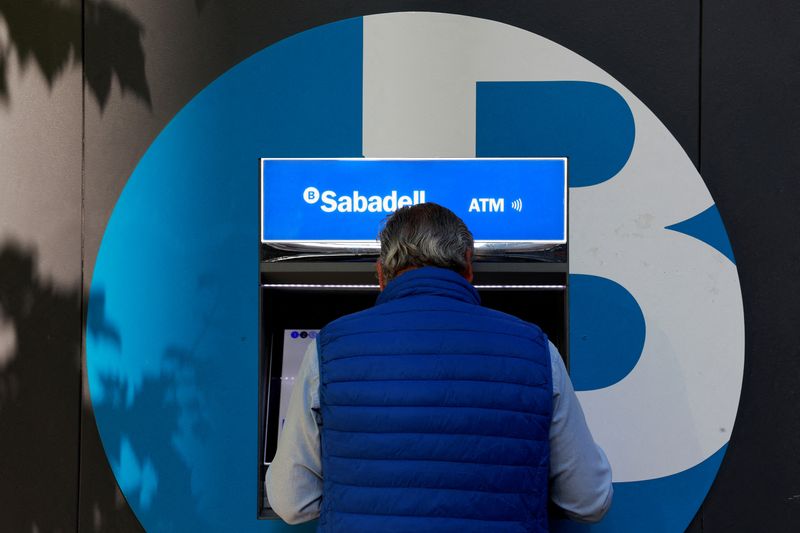  A man uses an ATM machine at a branch of Spain's Sabadell bank in Madrid, May 10, 2024. REUTERS/Susana Vera/File Photo