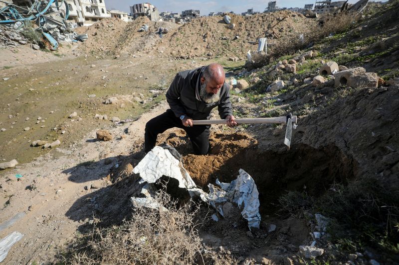 © Reuters. Palestinian man Atef Jundiya searches for the graves and bodies of his father, brother, and brother-in-law, at Shejaia cemetery, which was flattened by Israeli tanks and bulldozers during the war, following a ceasefire between Israel and Hamas, in Gaza City, January 20, 2025. REUTERS/Dawoud Abu Alkas   