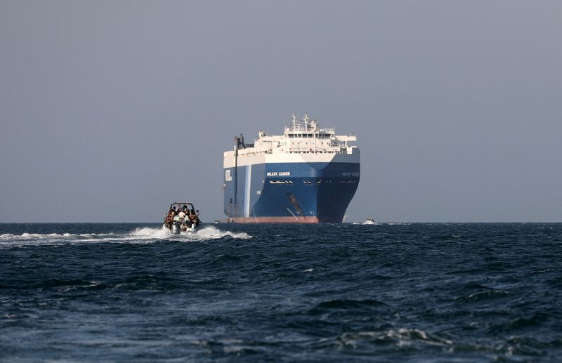 © Reuters. FILE PHOTO: A boat carrying people sails near the Galaxy Leader commercial ship, which was seized by Yemen's Houthis last month, off the coast of al-Salif, Yemen, December 5, 2023. REUTERS/Khaled Abdullah/File Photo