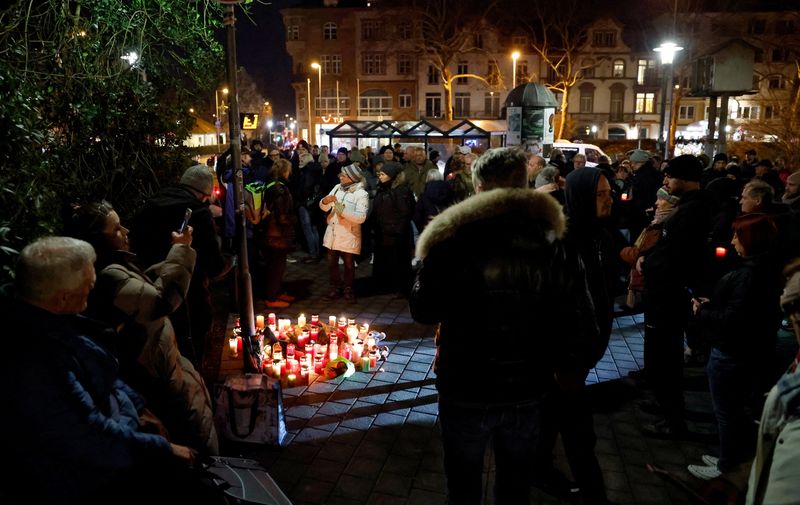 &copy; Reuters. Pessoas acendem velas durante protesto após ataque a faca que matou duas pessoas, uma criança entre elas, em Aschaffenburg, Alemanhan22/01/2025nREUTERS/Heiko Becker