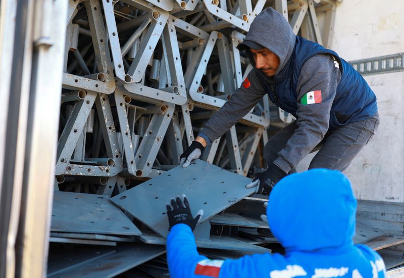 © Reuters. Workers unload construction materials from a trailer, where Mexican authorities will build a temporary shelter for migrants deported from the United States, in Ciudad Juarez, Mexico, January 21, 2025. REUTERS/Jose Luis Gonzalez