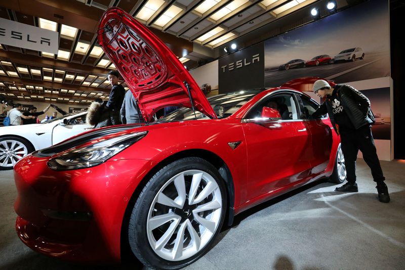 © Reuters. A visitor watches a Tesla Model 3 electric car at the Canadian International Auto Show in Toronto, Ontario, Canada, February 18, 2020. Photograph: Chris Helgren/Reuters.