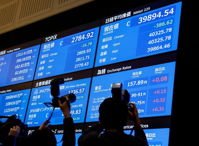 &copy; Reuters. Photographers take photos of the stock closing price and forex exchange rates on a board during a ceremony marking the end of trading in 2024 at the Tokyo Stock Exchange (TSE) in Tokyo, Japan December 30, 2024. REUTERS/Kim Kyung-Hoon/File Photo