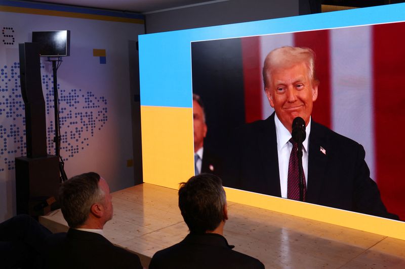 © Reuters. Delegates to the World Economic Forum watch Donald Trump's inauguration as U.S. President on a giant screen at the Ukraine House, on the opening day of the 55th annual meeting of the World Economic Forum (WEF) in Davos, Switzerland, January 20, 2025. REUTERS/Yves Herman/File Photo