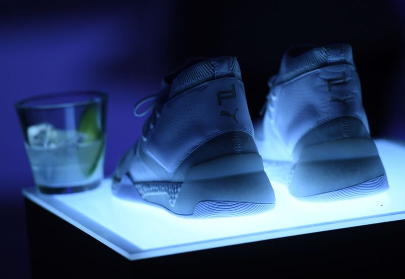  A pair of shoes is shown, next to a drink, as sports retailer Puma launches their sportswear collection in collaboration with Porsche Design in Berlin, Germany February 21, 2019. REUTERS/Annegret Hilse/File Photo