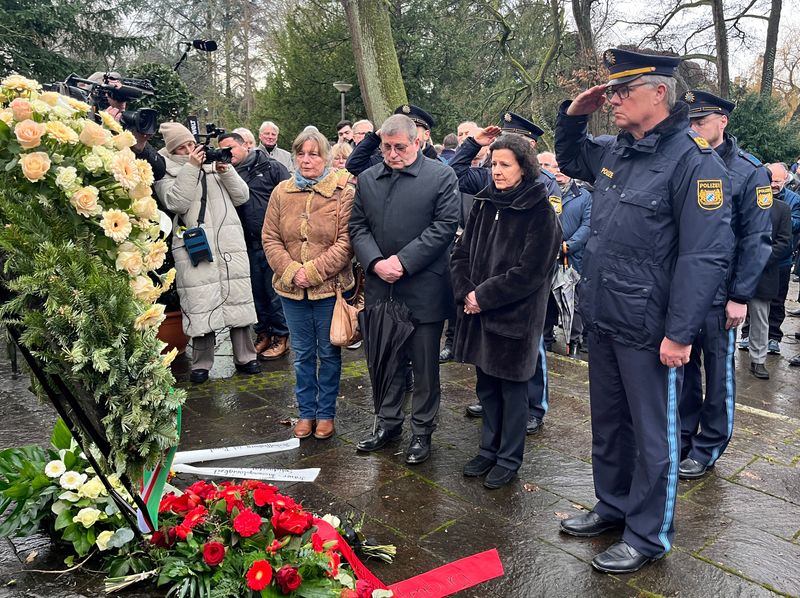 © Reuters. Police salutes in front of a wreath the day after two people, one a child, were killed in a knife attack, in Aschaffenburg, Germany, January 23, 2025. REUTERS/Tilman Blashofer