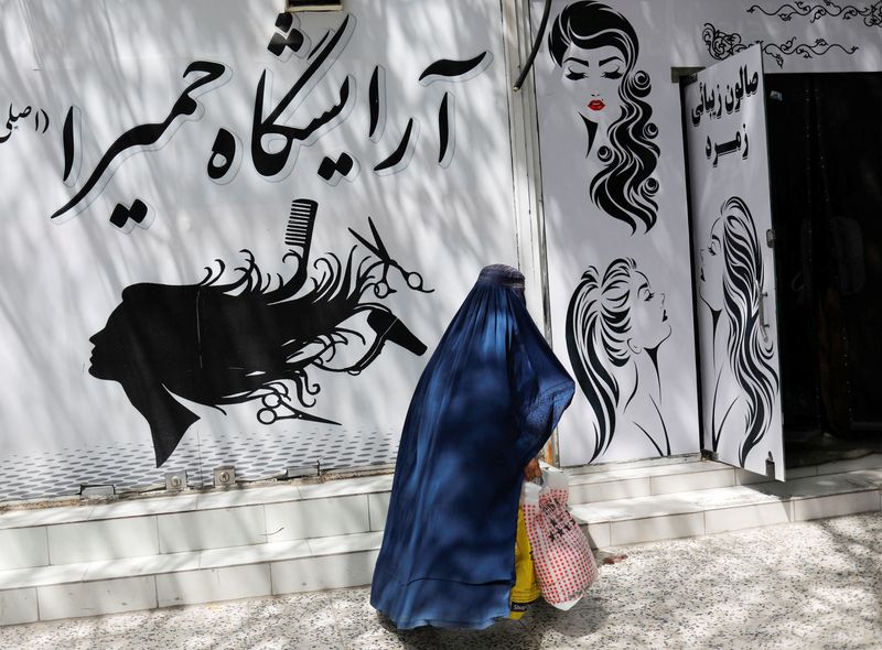 &copy; Reuters. FILE PHOTO: An Afghan woman walks past a beauty salon in Kabul, Afghanistan, July 6, 2023. REUTERS/Ali Khara/File Photo