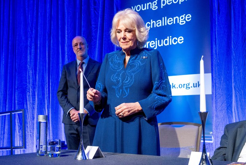 &copy; Reuters. Britain's Queen Camilla, patron of the Anne Frank Trust, lights a candle during a reception for Holocaust Memorial Day at the Hilton Park Lane in London, Britain, January 23, 2025. Arthur Edwards/Pool via REUTERS