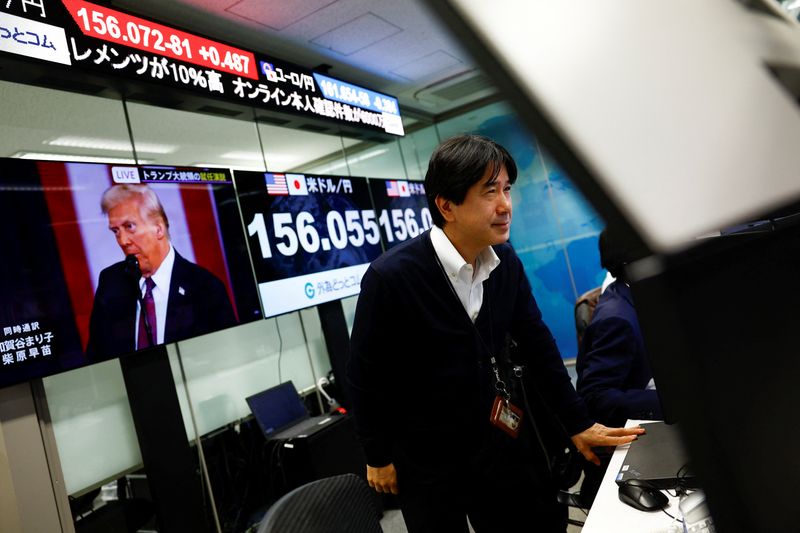 &copy; Reuters. Un uomo in un'azienda di brokeraggio Forex a Tokyo, davanti a schermi con il cambio Yen/dollaro e immagini del presidente Usa Donald Trump. REUTERS/Issei Kato