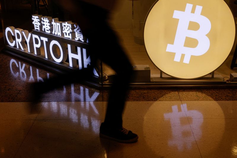 &copy; Reuters. FILE PHOTO: A man rushes past a cryptocurrency exchange store after Bitcoin soars above $100,000, in Hong Kong, China December 5, 2024. REUTERS/Tyrone Siu/File Photo