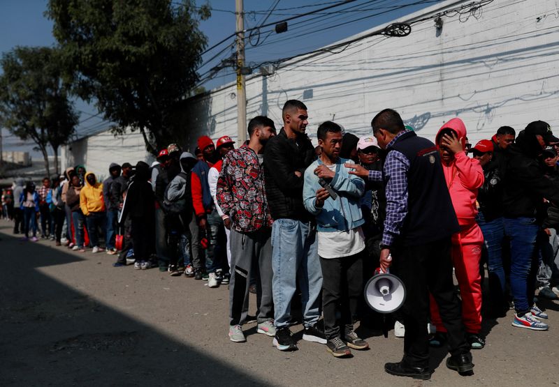 &copy; Reuters. An official of the Commission for Refugee Assistance (COMAR) talks with migrants outside the Mexican Commission for Refugee Assistance (COMAR), as they wait in line to regularise their migratory situation in the country, in Mexico City, Mexico January 24,