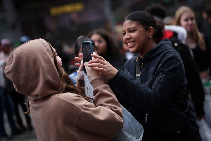 © Reuters. File Photo: On March 13, 2024, a young woman who creates a friend's video on a mobile phone to post to Tiktok in Times Square in New York, USA. Reuters/Mike Seager/File Photo