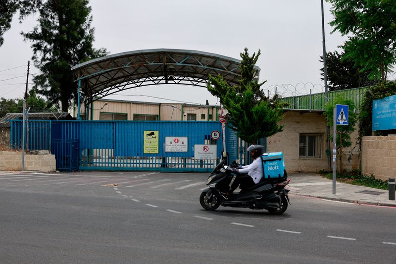 &copy; Reuters. FILE PHOTO: A man drives a scooter past the UNRWA headquarters, in Jerusalem, May 10, 2024. REUTERS/Ammar Awad/File Photo