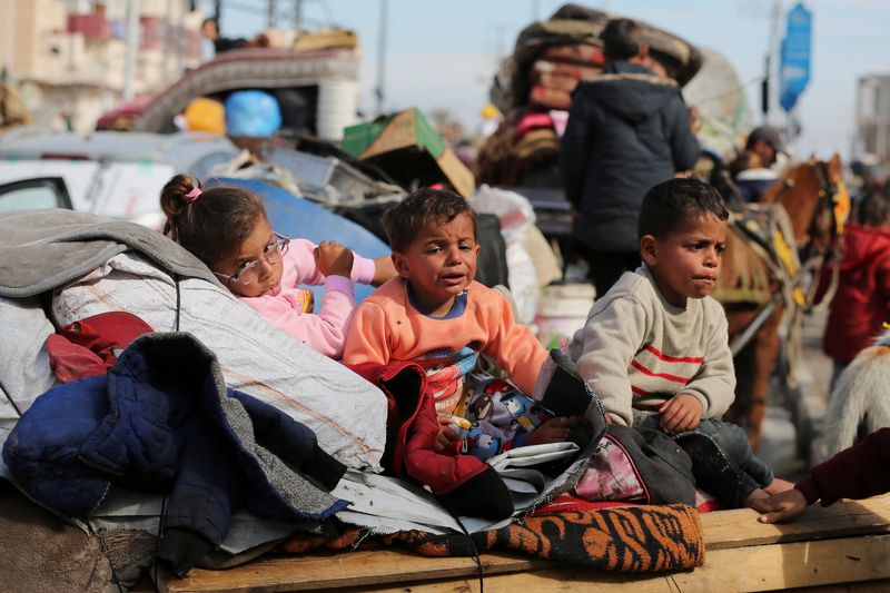 &copy; Reuters. Palestinian children wait to be allowed to return to their homes in northern Gaza after they were displaced to the south at Israel's order during the war, amid a ceasefire between Israel and Hamas, in the central Gaza Strip, January 26, 2025. REUTERS/Hate