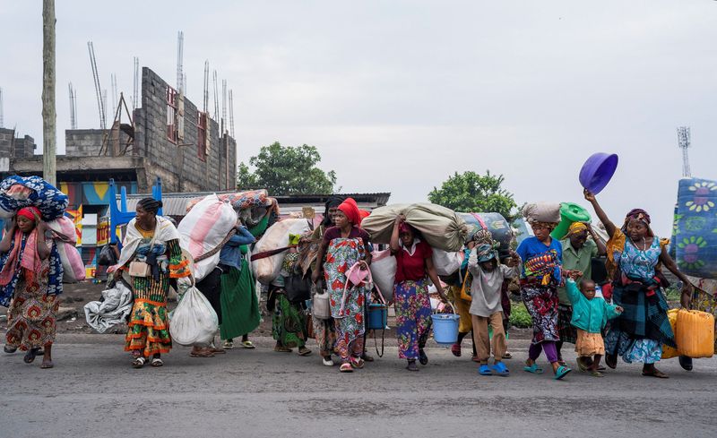 © Reuters. Internally displaced civilians from the camps in Munigi and Kibati, carry their belongings as they flee following the fight between M23 rebels and the Armed Forces of the Democratic Republic of the Congo (FARDC), in Goma, eastern Democratic Republic of Congo, January 26, 2025. REUTERS/Aubin Mukoni