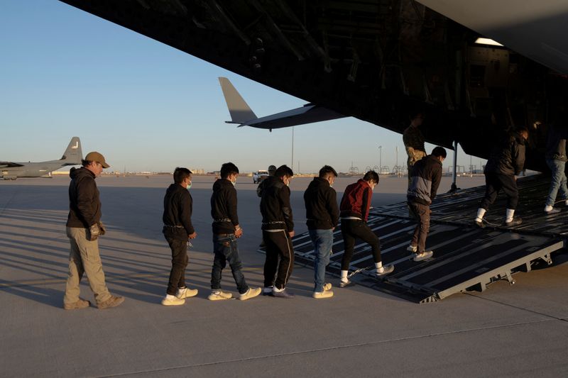 © Reuters. Migrants board a C-17 Globemaster III aircraft for a removal flight, Fort Bliss, Texas, January 23, 2025. Dept. of Defense/Handout via REUTERS