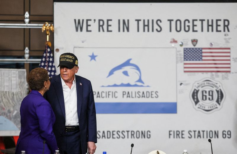 © Reuters. US President Donald Trump speaks with Los Angeles Mayor Karen Bass during a briefing on wildfire damage during his visit to the Pacific Palisades neighborhood damaged by the Palisades Fire, in Los Angeles, California, US, January 24, 2025. REUTERS/Leah Millis    