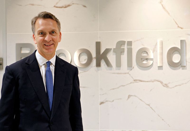 © Reuters. FILE PHOTO: Bruce Flatt, Chief Executive Officer of Brookfield Asset Management (BAM), poses in front of the company's logo in Tokyo, Japan, May 16, 2019.   REUTERS/Hideyuki Sano/File Photo