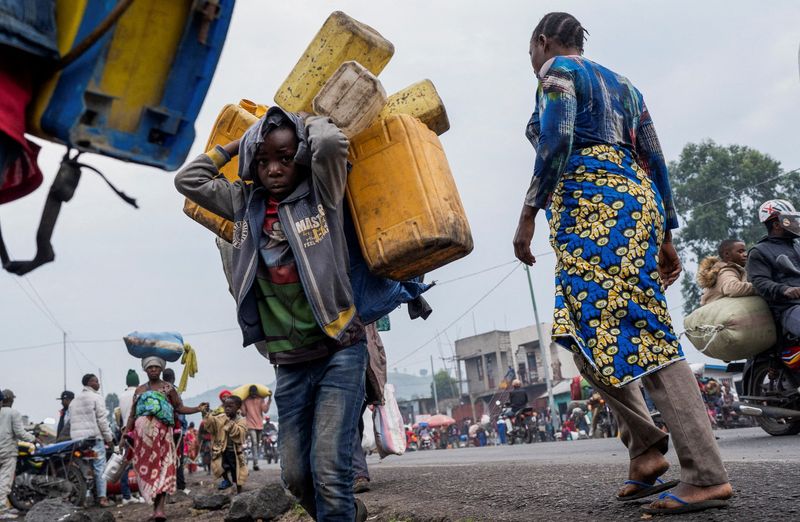 © Reuters. Civilians relocated to camps in Munigi and Kibati, carry their belongings as they flee fighting in Congo (Goma, Eastern Democratic Republic of Congo, January 26, 2025. Reuters/Aubin Mukoni     