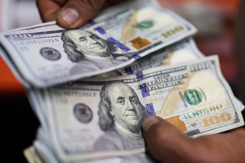 Dollar firms on Ukraine tensions, kiwi slumps as RBNZ slashes rates