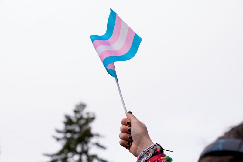 &copy; Reuters. Manifestante segura bandeira trans durante ato em apoio a jovens trans no hospital infantil de Seattle n 8/2/2025   REUTERS/David Ryder