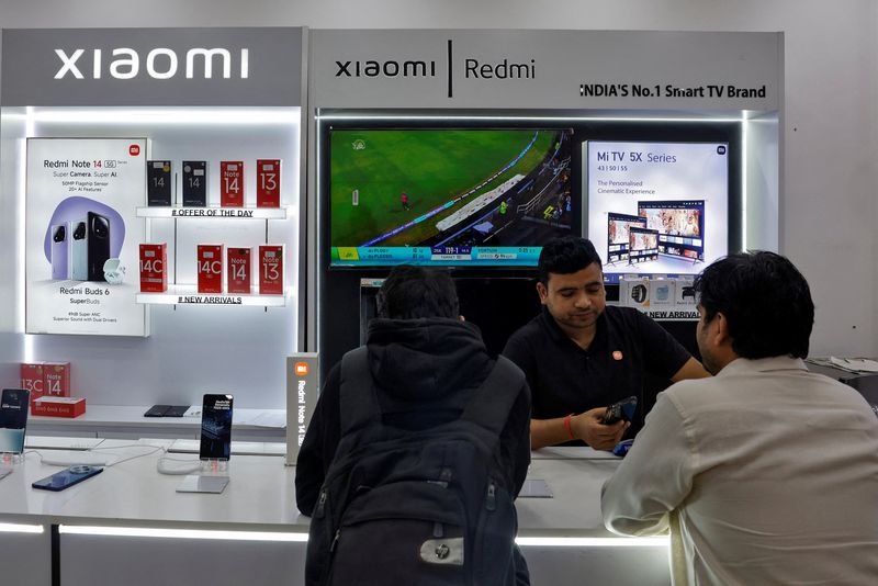 &copy; Reuters. Vendedor mostra mostra smartphone da Xiaomi em loja de Nova Delhi, Índian01/02/2025nREUTERS/Priyanshu Singh/File Photo